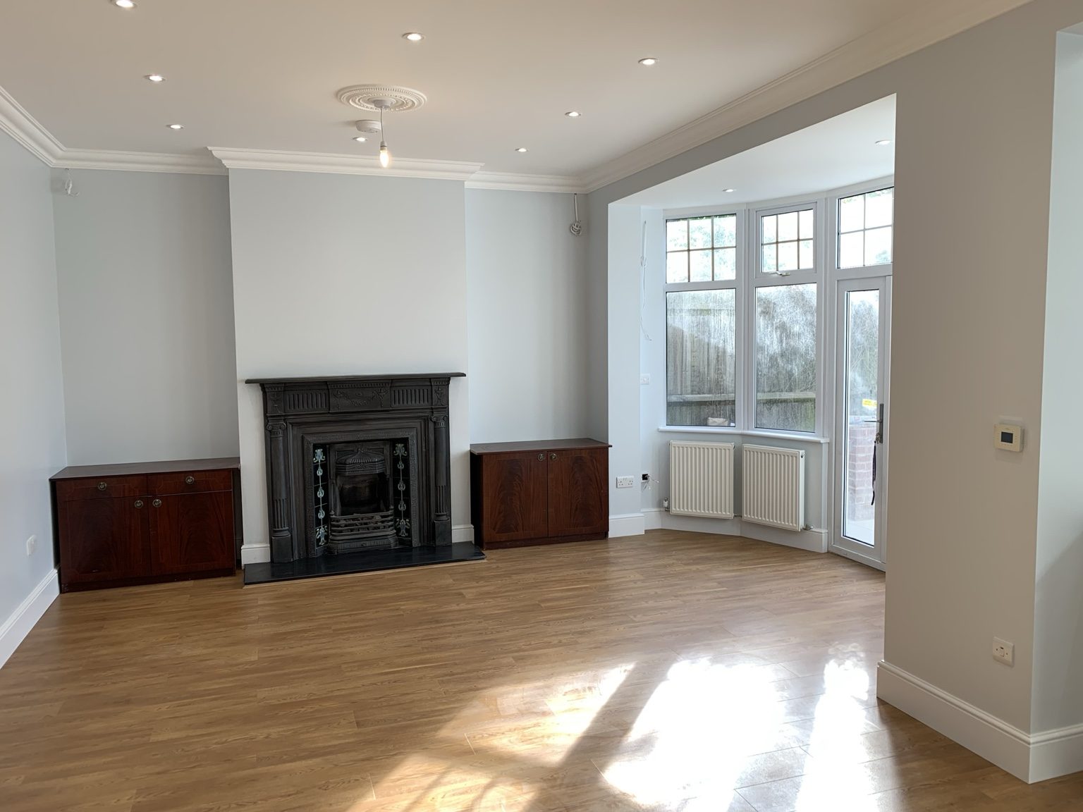 Living room renovation with fireplace and wood flooring