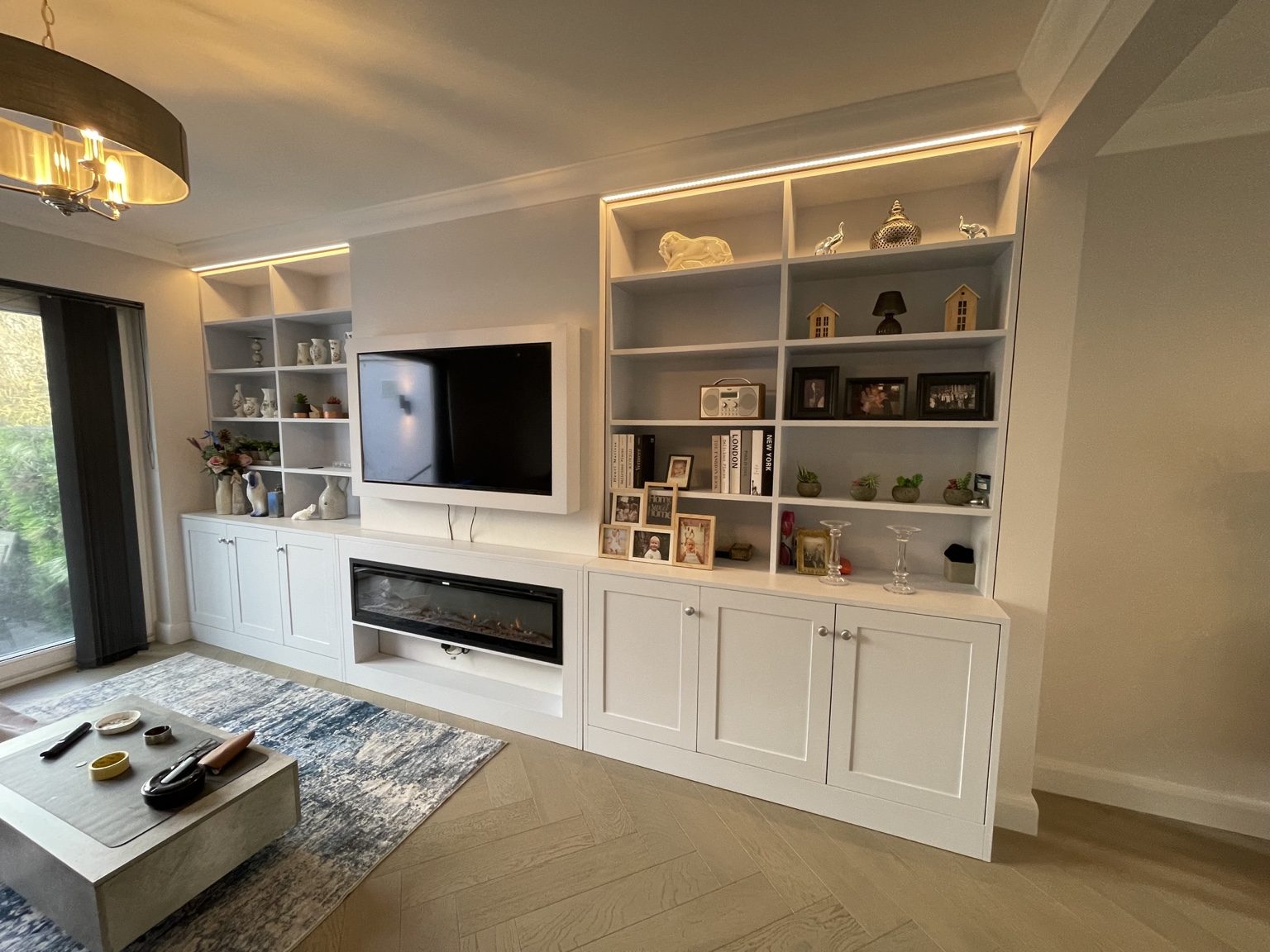 Living room with fitted shelving, television and fireplace