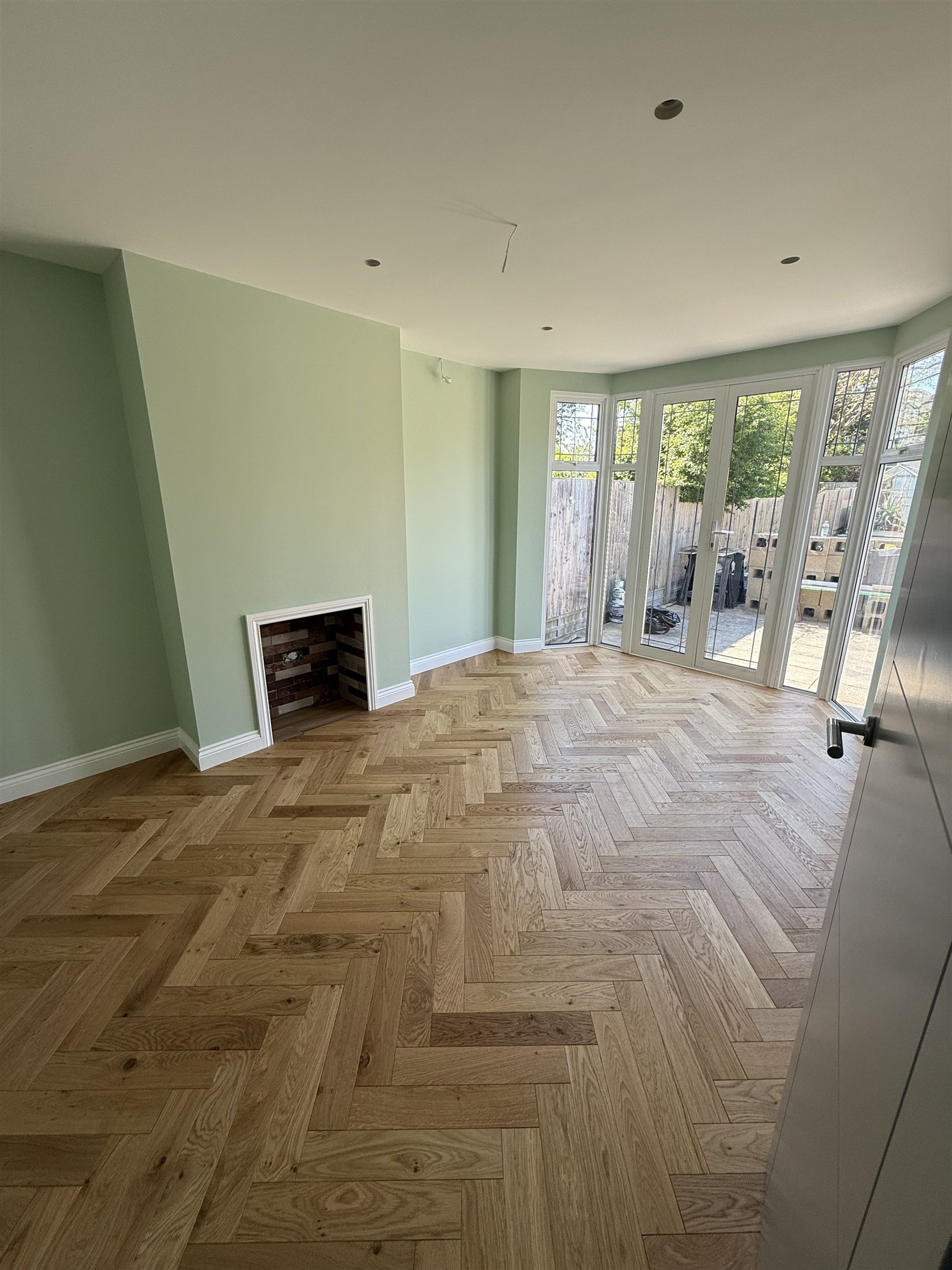 Renovated living space with oak parquet flooring and garden doors