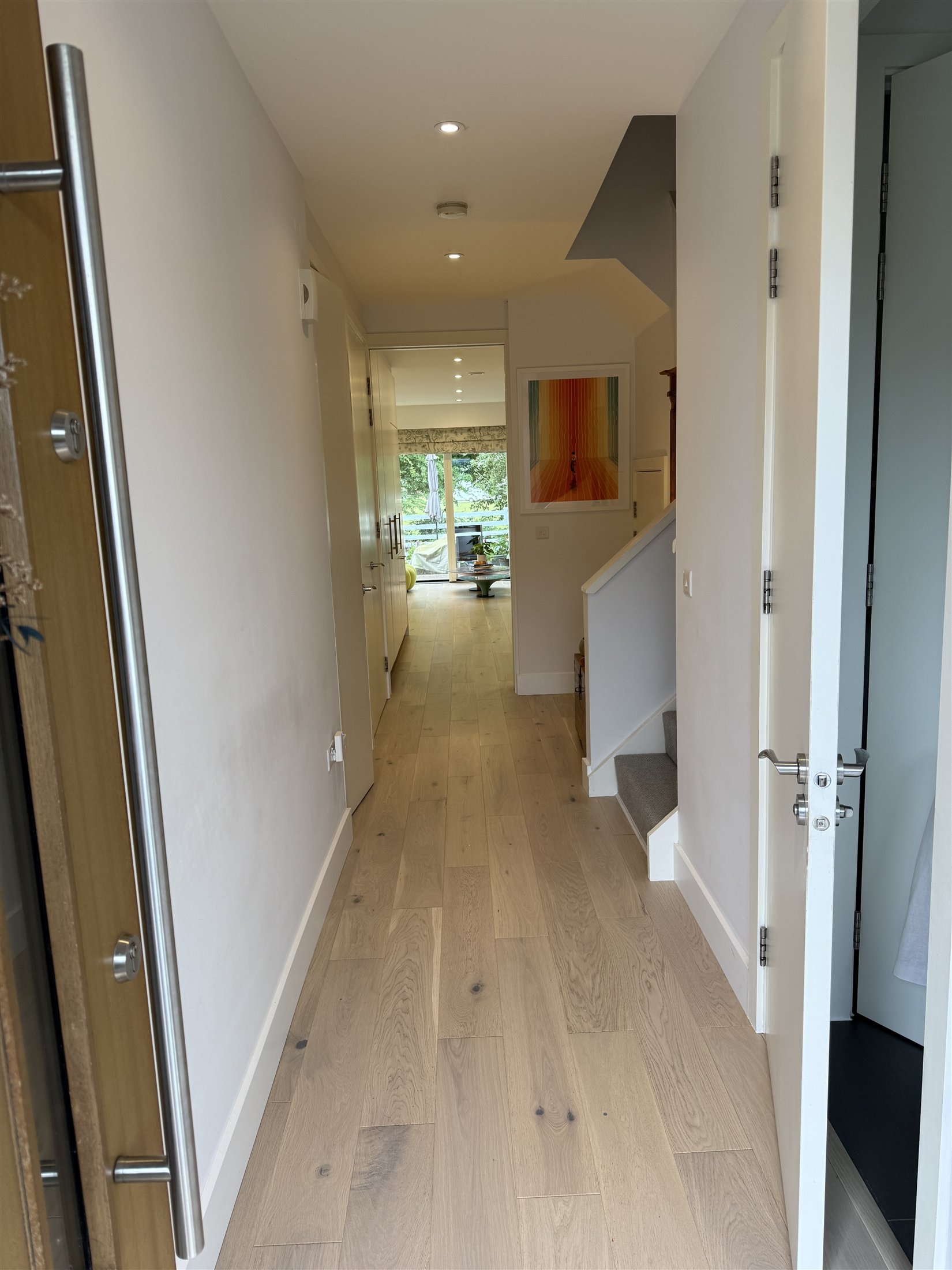 Bright interior with staircase, fitted joinery and wood flooring